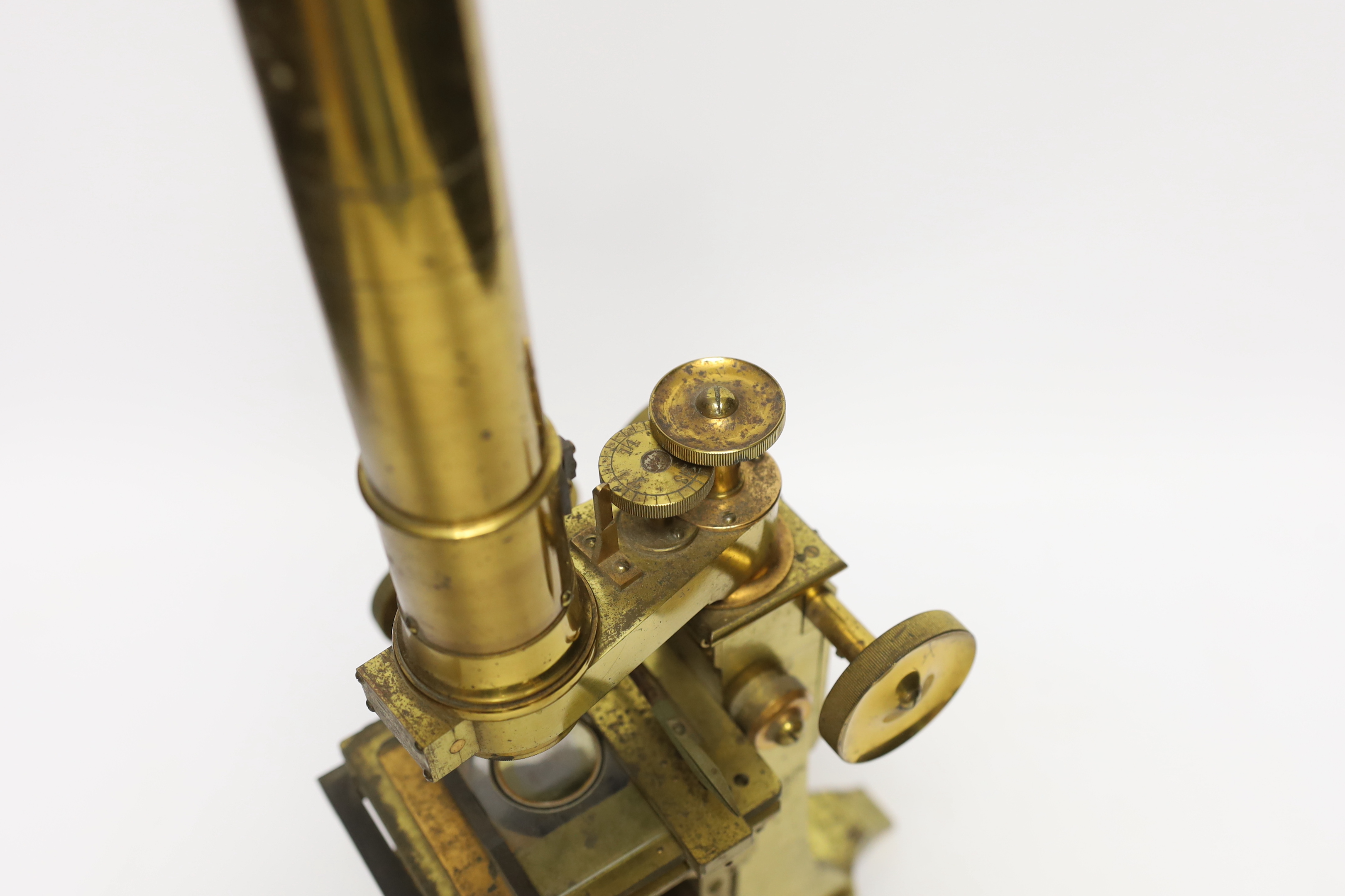 A brass microscope with mahogany box by A. Ross of London, dated 1890 to foot, with some unusual features including a rotating box under the bed for lens, box with fitted interior containing additional lens and other att